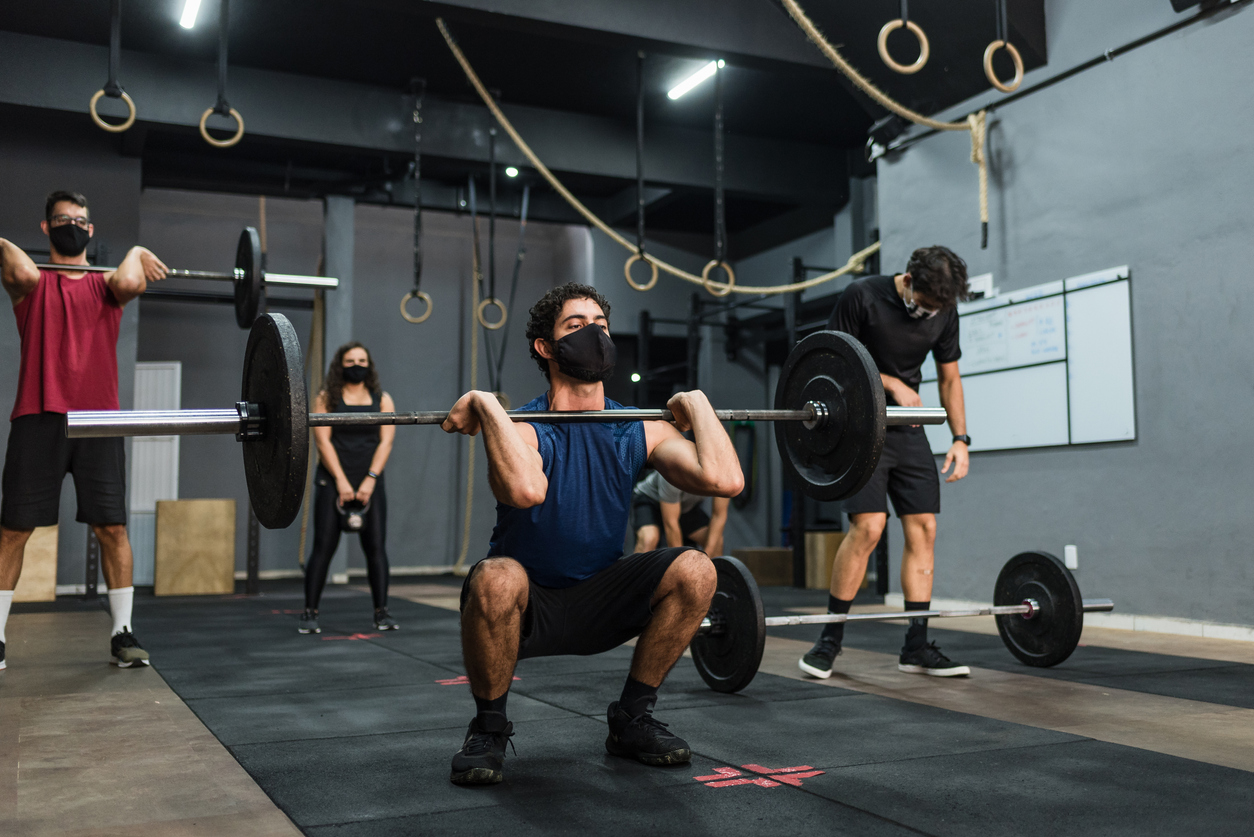 Athletes lifting weight wearing protective mask